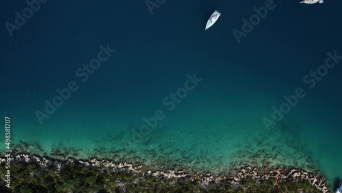 Aerial view of water sea surface and nautical vessels with piers on it located next to coastal town. Drone footage of Kas in Turley with its docks and moored yachts. Mountain city in the azure harbor. photo