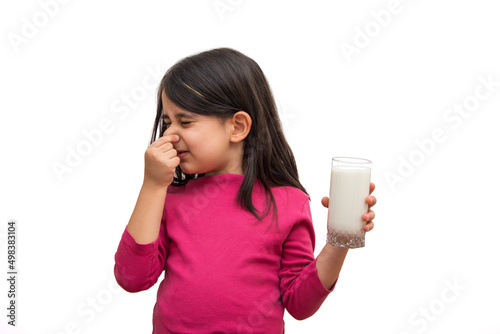 Little girl who doesn't want to drink milk on a white background