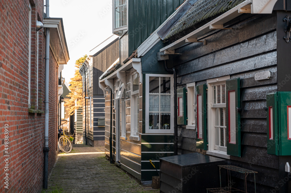 Walking on sunny day in small Dutch town Marken with wooden houses located on former island in North Holland, Netherlands