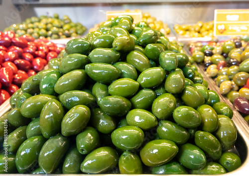 Green fresh olives close up on market, food background