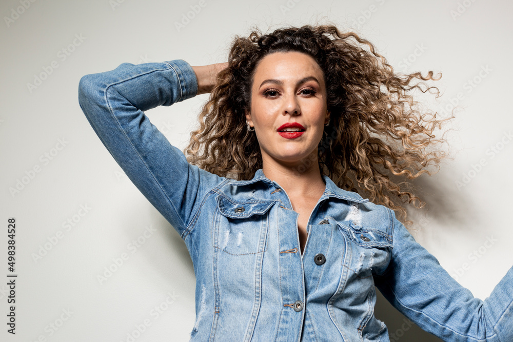 Studio shot of proud young girl with perfect light brown skin and beautiful curly hair in empowerment pose on a white background. Studio shot of proud young girl with perfect light brown skin and beautiful curly hair in empowerment pose on a white background.