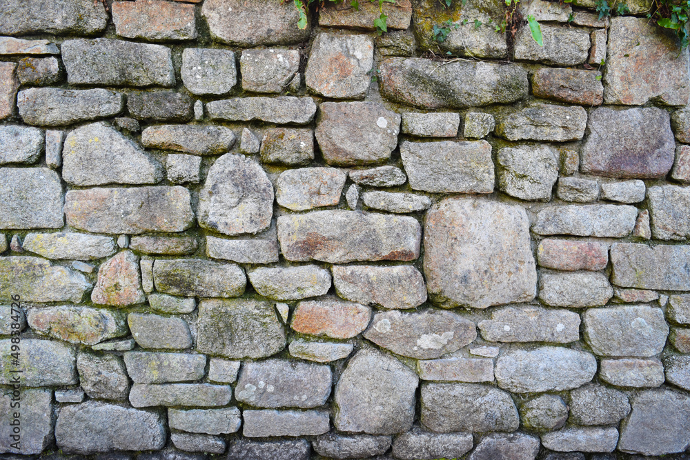 ancient wall done with granite stones along a river in Brittany, France ancient wall done with granite stones along a river in Brittany, France