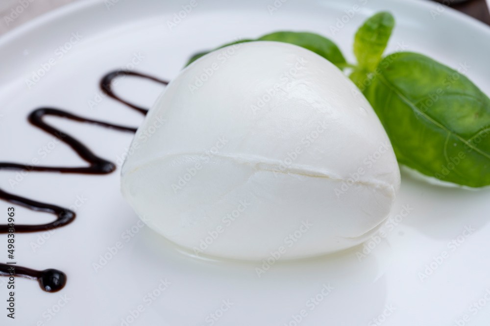 Fototapeta premium Tasing of fresh italian cheese mozzarella di buffalo with Balsamic vinegar from Modena