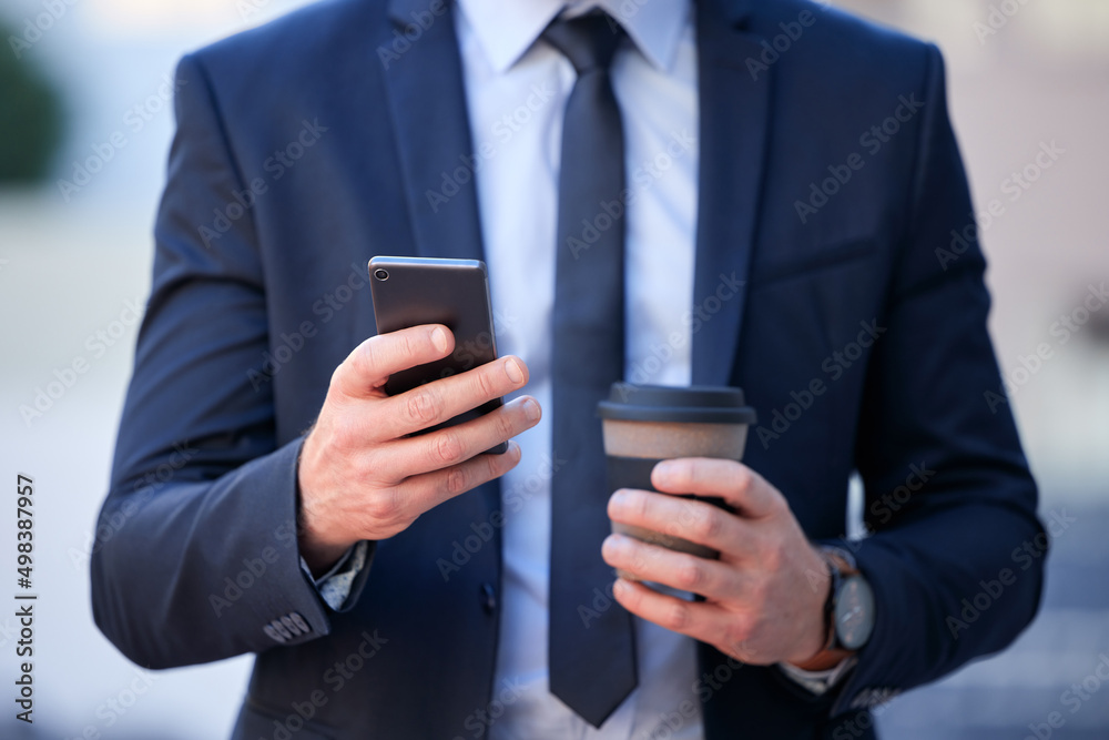 Thanks to technology, youre never far from the office. Cropped shot of an unrecognizable businessman texting while standing outside in the city. Thanks to technology, youre never far from the office. Cropped shot of an unrecognizable businessman texting while standing outside in the city.