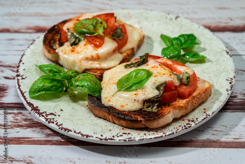 High view of a Brusqueta with mozzarella caprese, tomato and hot basil. Traditional and mediterranean food concept.