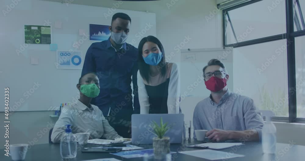 Animation of data processing over diverse business people with face masks using laptop Animation of data processing over diverse business people with face masks using laptop
