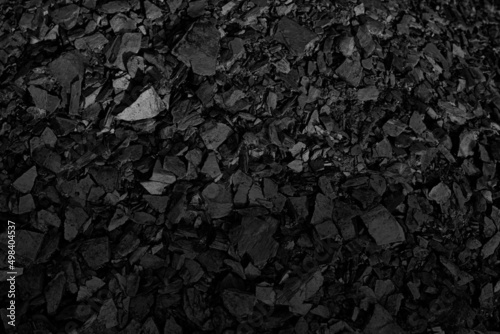 A heap of black natural coal, photo of coal mine background, texture. Natural energy sources. The world's main fuel source for electricity generation.	