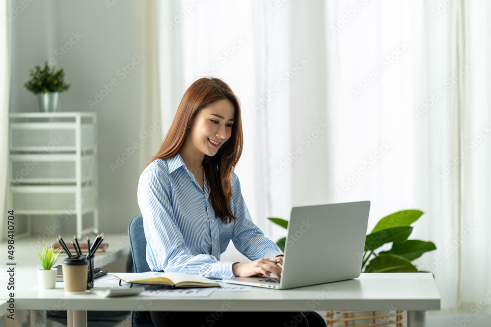 asian businesswoman sitting working on laptop in office. asian businesswoman sitting working on laptop in office.