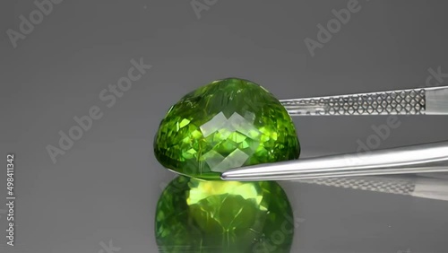 natural gemstone green tourmaline cushion cut in the tweezers