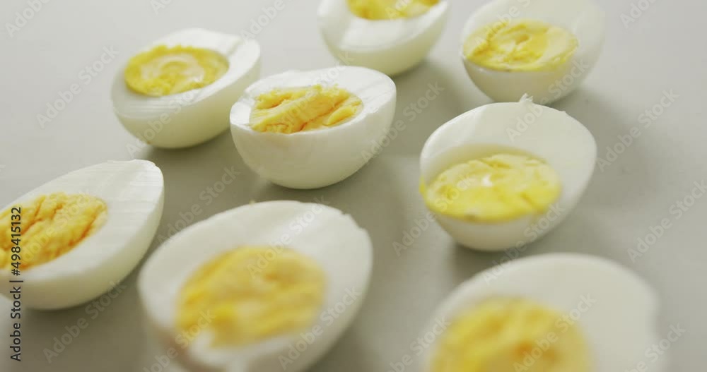 Video of close up of halves of hard boiled eggs on grey background Video of close up of halves of hard boiled eggs on grey background