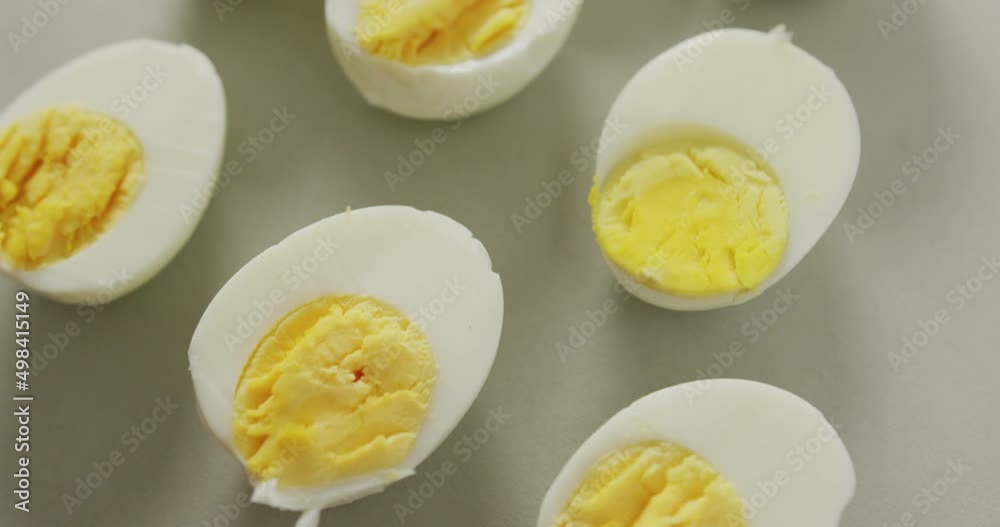 Video of close up of halves of hard boiled eggs on grey background Video of close up of halves of hard boiled eggs on grey background