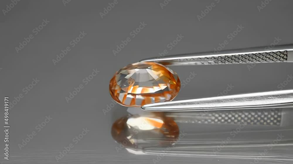 natural gemstone yelow zircon oval cut in the tweezers natural gemstone yelow zircon oval cut in the tweezers
