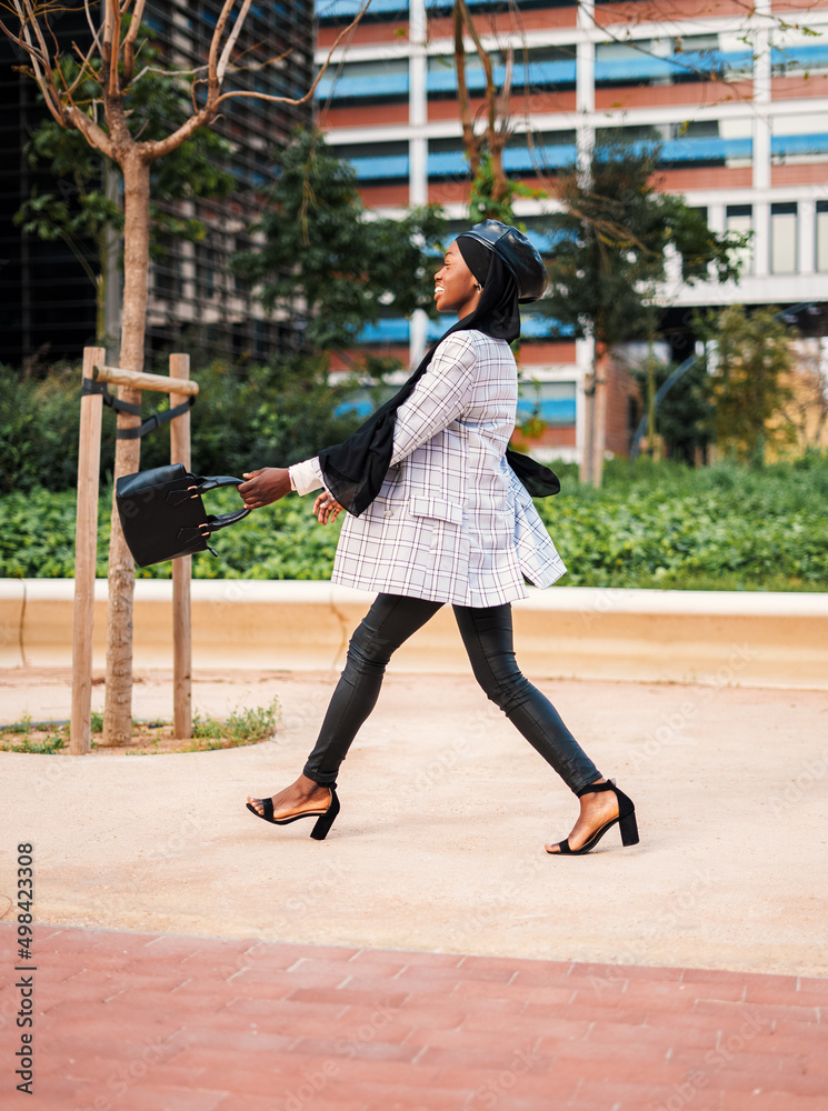 Obraz premium Stylish black woman enjoying pleasant walk in city park