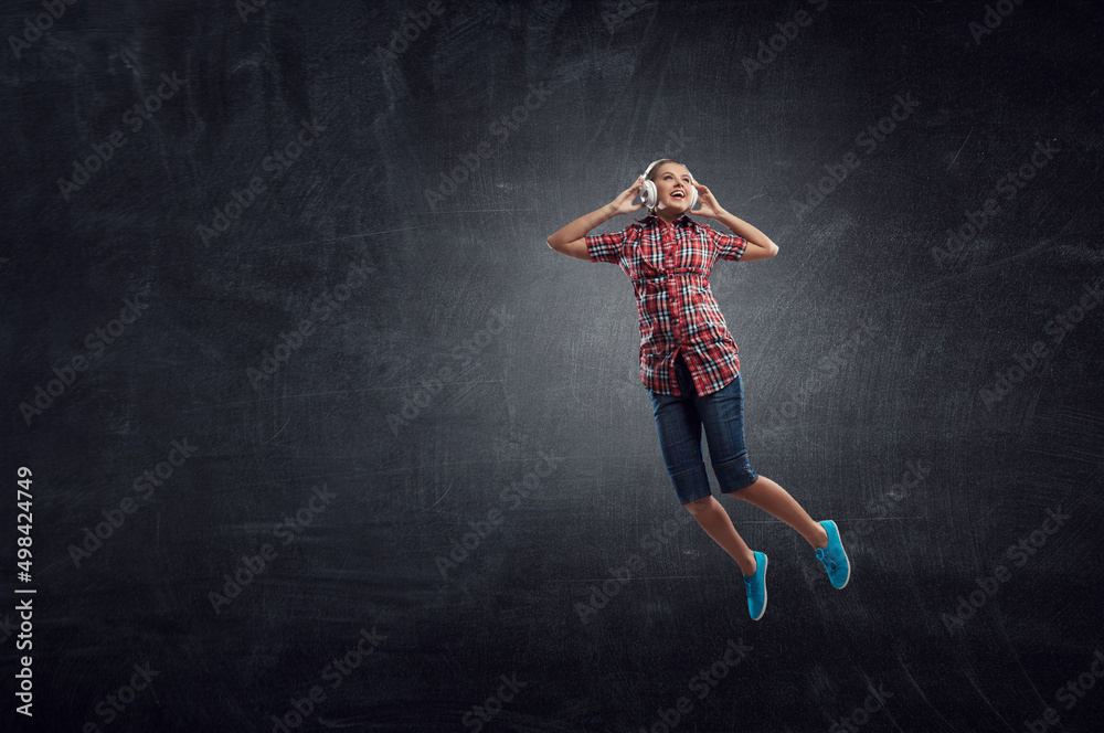 Woman wearing headphones jumping . Mixed media