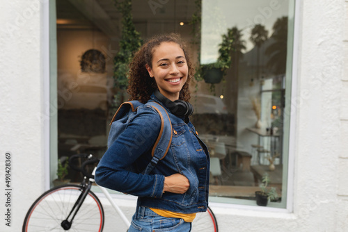 Portrait of smiling young african american woman with hand in denim jacket pocket photo