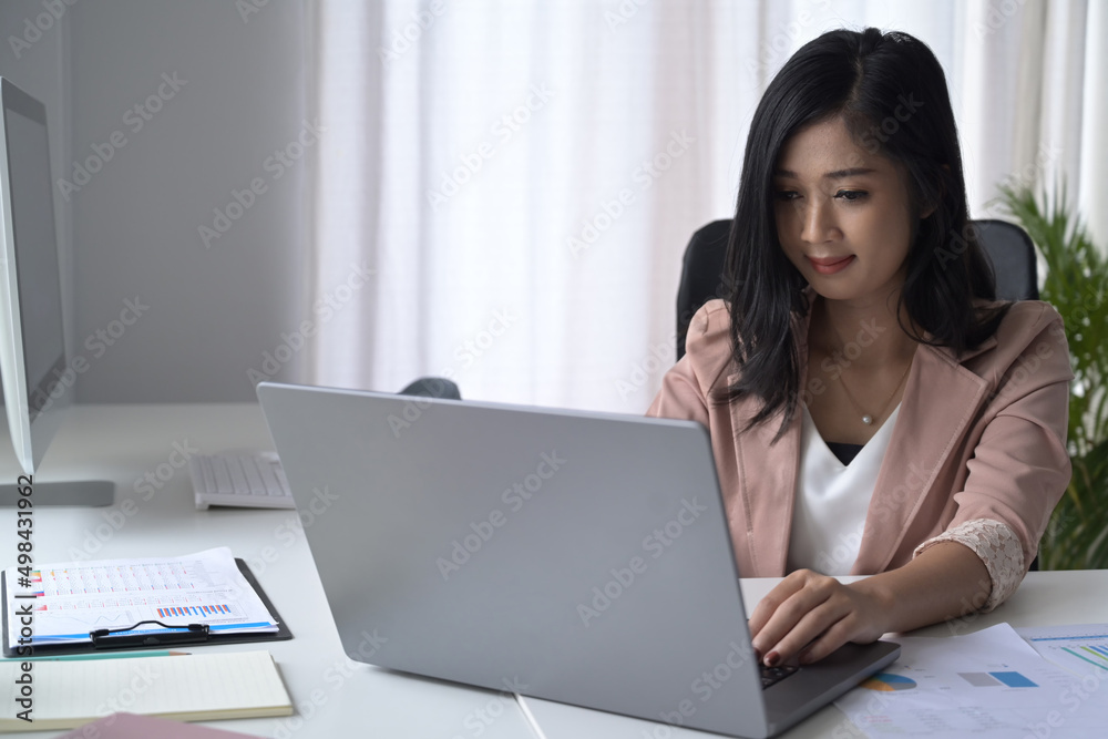 Pretty young woman using laptop computer at modern office. Pretty young woman using laptop computer at modern office.