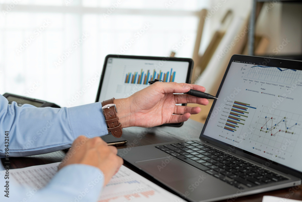 Business hands pointing for checking report chart on laptop. Businessman analyzing financial report company and calculate profit with report summary.