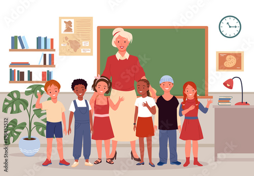 Primary school children and teacher vector illustration. Cartoon portrait of female teacher standing with joyful students in classroom interior with class board and waving. Pedagogy, education concept