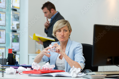 stress female office worker with crumpled paper