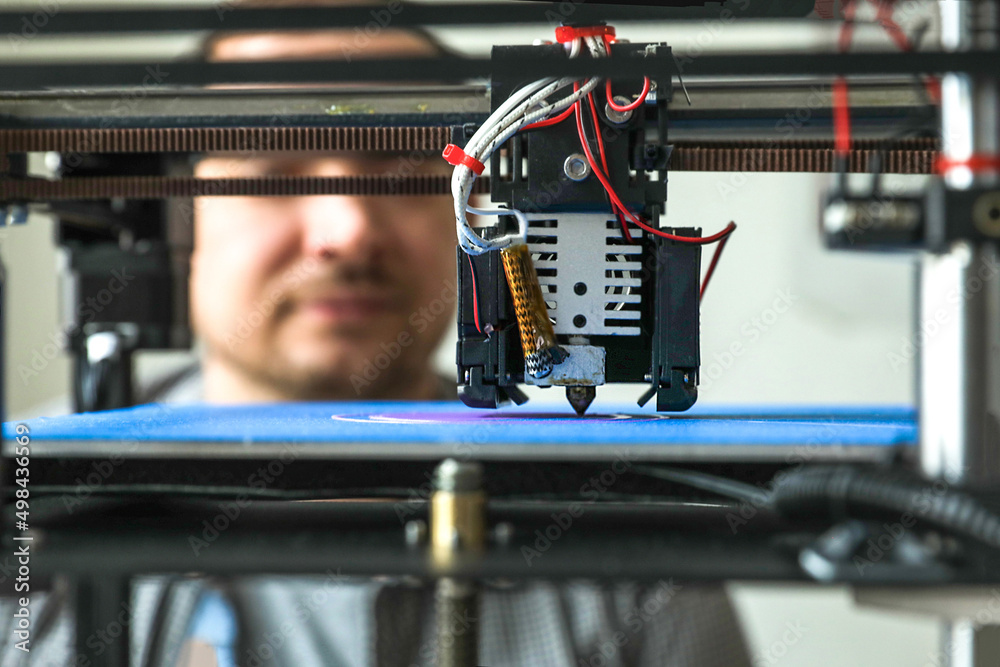 Naklejka premium An engineer is setting up a machine for 3D printing, a printer for volumetric printing of parts.