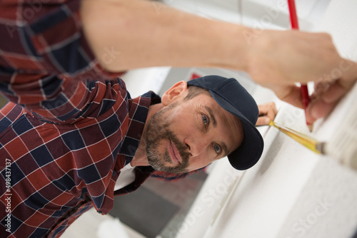 a man measuring cupboard door