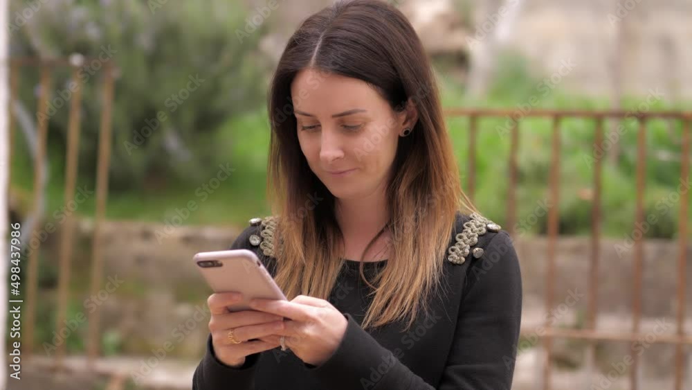 Woman hold and touching mobile screen writing a message Woman hold and touching mobile screen writing a message