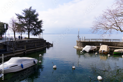 Lakeshore with idyllic port and moored boats at Village of Veytaux, Canton Vaud, with Lake Geneva on cloudy spring day. Photo taken April 4th, 2022, Veytaux, Switzerland.