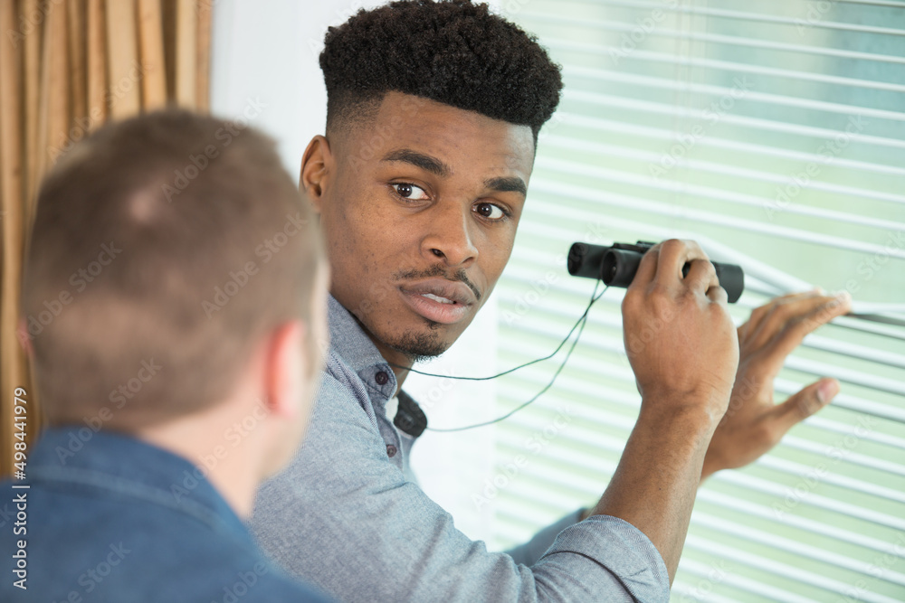 young men look out the window through binoculars young men look out the window through binoculars