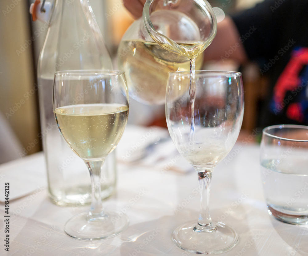 Italian white house wine served in pitcher with two glasses for dinner