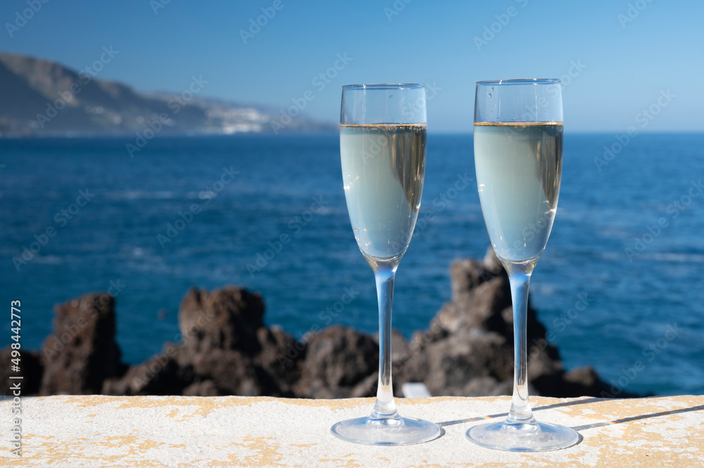 New year celebration with two glasses of champagne or Spanish cava sparkling wine and view on blue Atlantic ocean, Canary islands, winter tourists destination