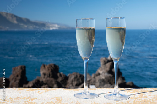 New year celebration with two glasses of champagne or Spanish cava sparkling wine and view on blue Atlantic ocean, Canary islands, winter tourists destination