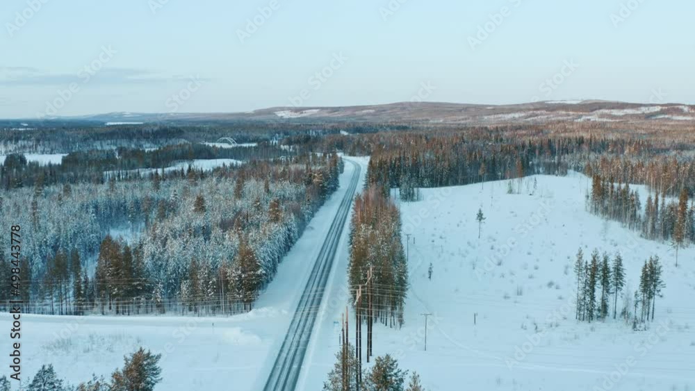 Aerial view of winter road in the forest. Trees and roadsides covered with snow in a beautiful landscape with spruces. Aerial view of winter road in the forest. Trees and roadsides covered with snow in a beautiful landscape with spruces.