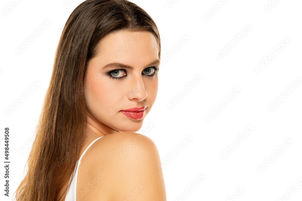 Beautiful serious woman with make up and long hair on a white background