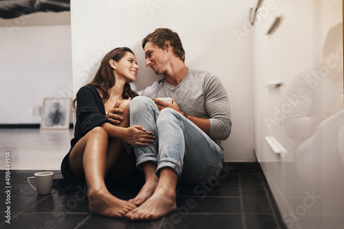 I feel at home in your eyes. Shot of an affectionate young couple sitting on the kitchen floor.