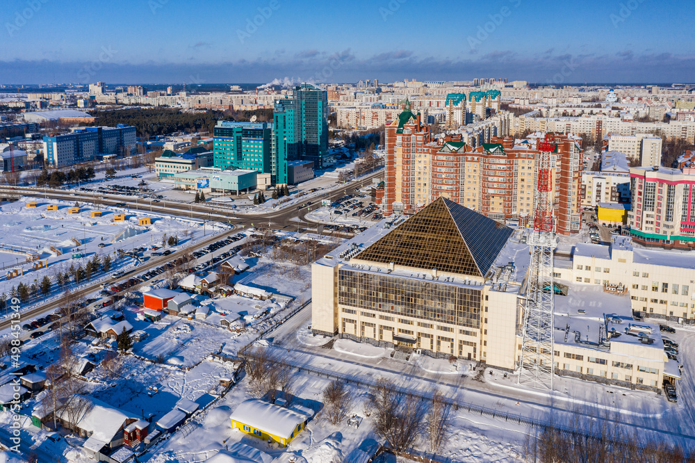 Surgut city in winter. The building of the distribution electric grid company Rosseti Tyumen (Tyumenenergo). Aerial view.