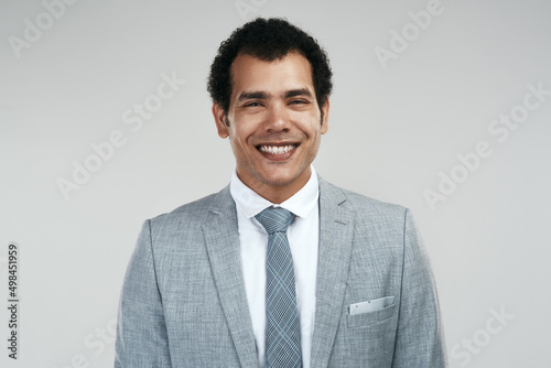 Nothing brings greater joy than achieving something that was once a dream. Studio shot of a confident businessman standing against a grey background.