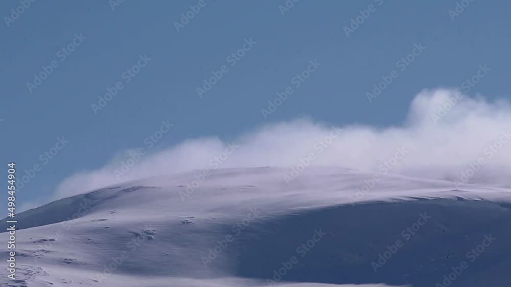 clouds rolling over snow covered mountain. Time lapse. Backlit. clouds rolling over snow covered mountain. Time lapse. Backlit.