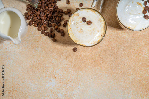 Cold dairy coffee drink with milk  whipped cream. Foamy frappe  latte  cappuccino  on a cream background  space for text. Summer cold coffee cocktail