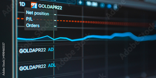 Daily trading gold prices on the online stock market graph showing on color screen.Daily investor's business everyday life.Banner,selective focus.Telsiai,Lithuania.03-26-2022