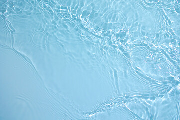 Transparent blue clear water surface texture with ripples, splashes and bubbles. Abstract nature background Water waves in sunlight. Cosmetic moisturizer micellar toner emulsion. Top view, copy space