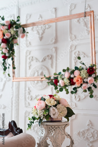 Wooden frame decorated with artificial flowers. Wedding composition. Flowers on a stand.