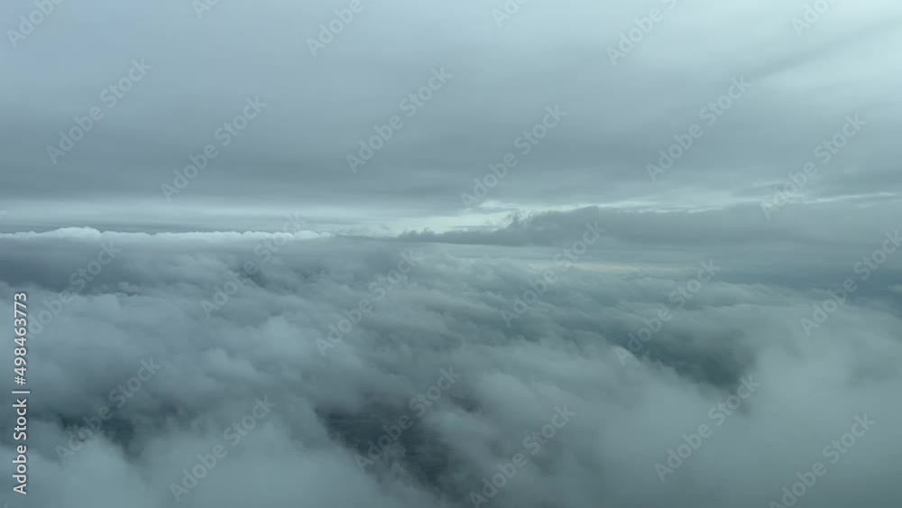 Cockpit view flying trough layers of clouds in a cold winter day