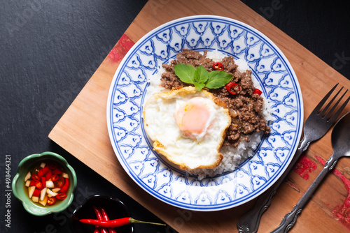 Thai Food concept Khao pad krapow rice and minced beef Thai holy basil stir-fry with fried egg in thai style ceramic plate with copy space