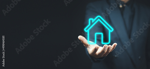 Real estate concept, businessman holding a house icon.House on Hand.Property insurance and security concept.