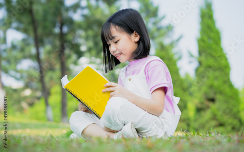 Image of Asian little girl studying at park