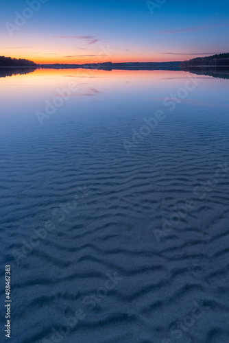 Background image of calm lake with rippled sand in shallow water at dusk  M  ritz National Park  Germany