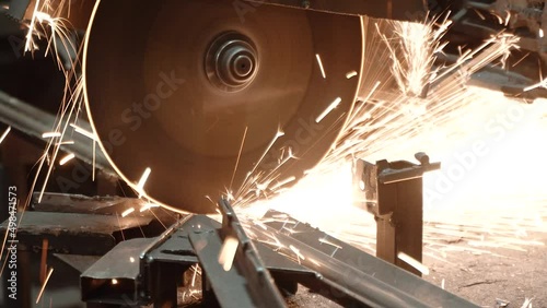 Heavy Industry Engineering Factory Interior with Industrial Worker Using Angle Grinder and Cutting a Metal Tube. Contractor in Safety Uniform and Hard Hat Manufacturing Metal Structures. a worker with