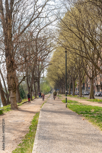 Road, bike path. A person riding a bike. Park on a spring day, people enjoying the outdoors.