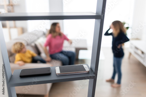 Smartphones on ladder in room with mother with children photo