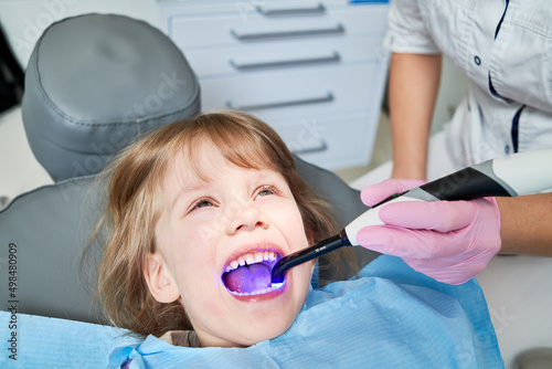 Children dentistry. Litle girl an dentist examination, teeth cleaning and treatment.